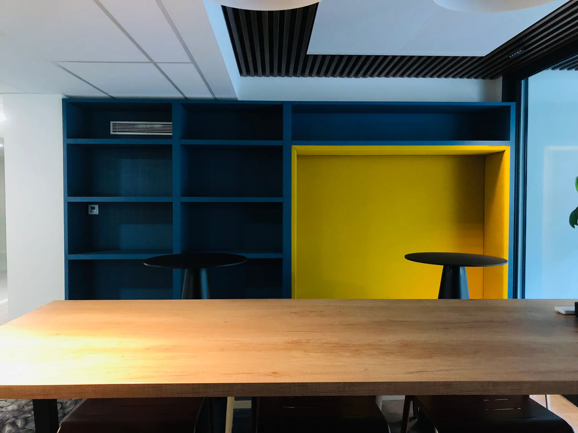 Espace de réunion informel avec mobilier intégré bleu et jaune