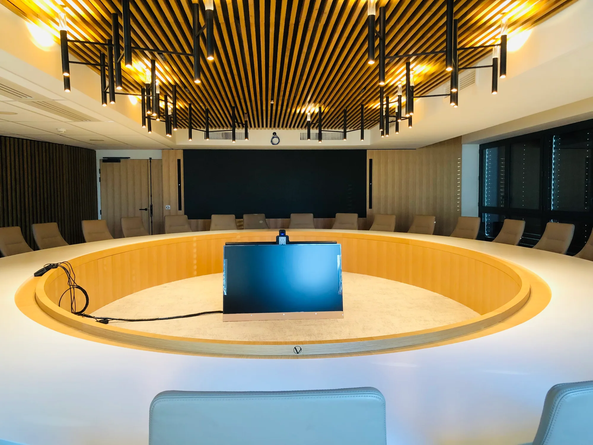 Salle de conférence avec table ronde centrale et sièges disposés autour